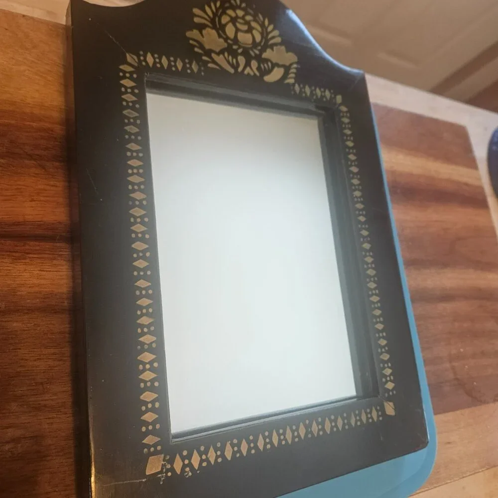 vintage style accent mirror with a black frame with gold stenciling small 8x12